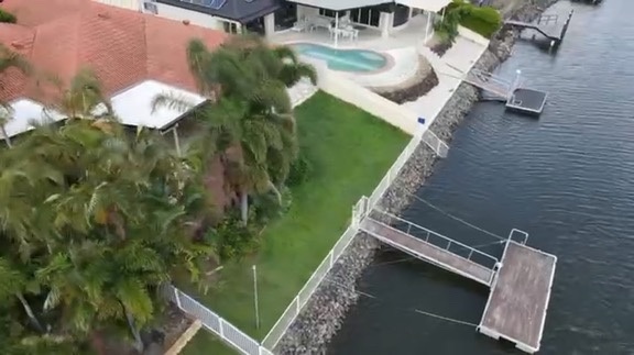 Aerial view of the Helensvale waterfront home, garden, canal and pontoon before renovation
